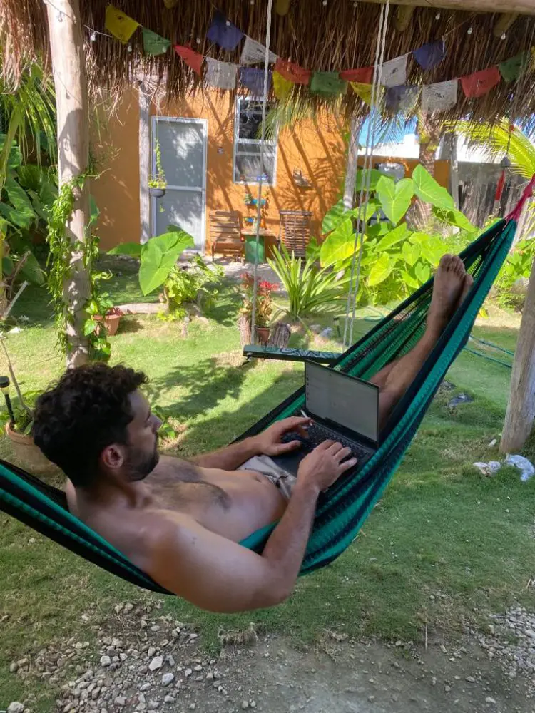 digital nomad working on a hammock